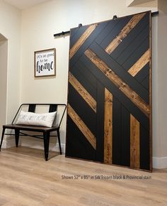 a room with a black and white striped wall next to a wooden bench in front of a large sliding door