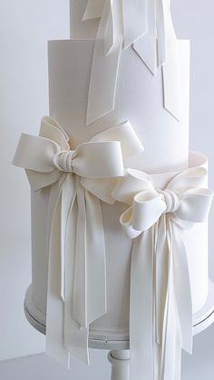 a white wedding cake with bows on top