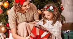 a mother and daughter opening a christmas present