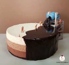 a cake with chocolate icing and miniature people on the top is being made to look like an ice cream sundae