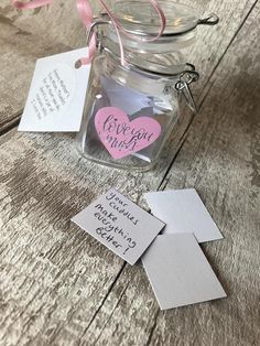 a glass jar with some pink hearts in it and two tags attached to the lid