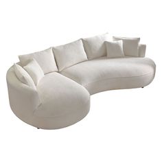 a large white sectional couch with pillows on it's back and arms, sitting in front of a white background