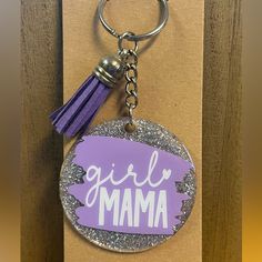 a purple keychain with the word girl mama on it and a tassel