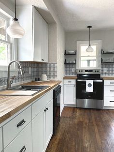 a kitchen with wood floors and white cabinets