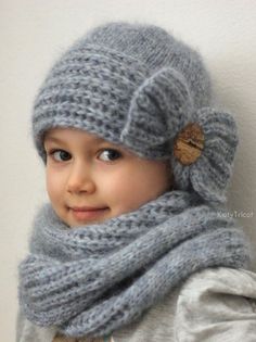 a little boy wearing a knitted hat and scarf with a button on the side