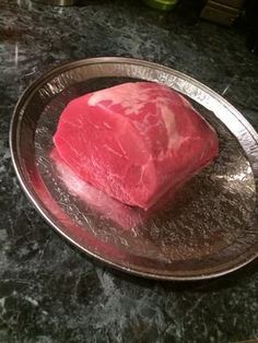 a piece of raw meat sitting on top of a metal plate