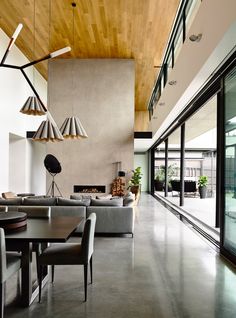 a living room filled with furniture next to a large glass window covered in wood planks