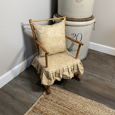 a chair sitting on top of a hard wood floor next to a bucket and rug