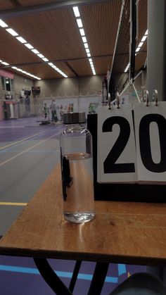 a table with a water glass on it next to a sign that reads twenty two