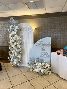 a table with flowers on it and a sign that says bride to be in the center