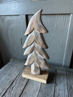 a wooden christmas tree sitting on top of a wooden table