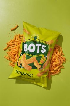 a bag of bots sitting on top of a green table next to french fries