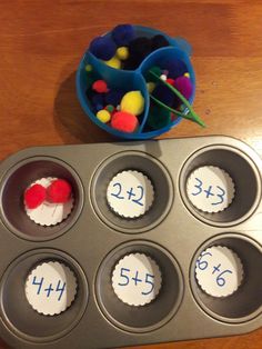 cupcakes with numbers and candy in them sitting on a table next to a muffin tin