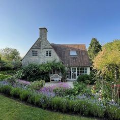 the house is surrounded by flowers and greenery