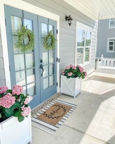 two potted flowers are on the front porch