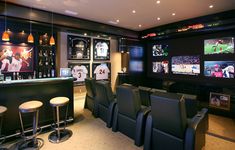 a sports themed home bar with seats and televisions