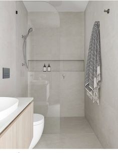 a bathroom with a sink, toilet and bathtub next to a wall mounted shower head