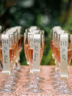 there are many wine glasses that have names on them, and one is filled with champagne