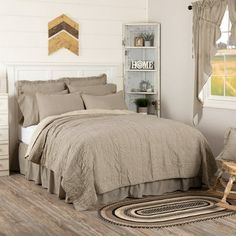 a bed room with a neatly made bed next to a window and a rocking chair