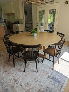 a dining room table with chairs and a potted plant