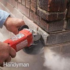 a man using a power drill to fix a brick wall