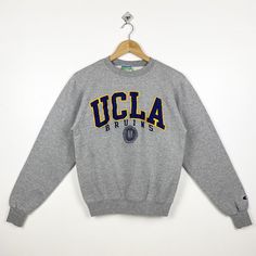 Vintage NCAA UCLA 'Bruins' Crewneck Sweatshirt Embroidery Logo Grey Color Men's XS - Made in Honduras - Materials : Cotton, Polyester  - Tag Reads : XS Kindly see the actual measurements (All measurements were taken lying flat) - Actual size manual measurements * Width (Armpit to armpit) : 19 inches * Length (Shoulder to end of garment) : 24 inches * Sleeve length : 25 inches - Condition : * Vintage condition 8/10 (80%) * Minor stain refer picture  * Free from any stain and major defect - Shippi Varsity Tops With Embroidered Logo For Campus, Varsity Tops With Embroidered Graphics For Campus, Varsity Style Embroidered Tops For Campus, Collegiate Sweatshirt With Embroidered Graphics, Collegiate College Tops With Embroidered Logo, Collegiate Tops With Embroidered Logo For College, Streetwear Tops With Embroidered Logo, Embroidered Logo Tops For College Style Streetwear, Collegiate Crew Neck T-shirt For Winter