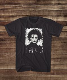 His story will touch you, even though he can't. This classic Johnny Depp and Tim Burton retro movie shirt bring back the 90s nostalgia. * All of our items are handmade and made to order!* All of our garments are high quality, name brand apparel like Fruit of the Loom, Gildan, Anvil and Bella & Canvas. The brand and style of garment is always specific to the listing/design. If you would like a certain design printing on something different than shown in the listing, please send us a convo and we will make you a custom order :) Sizes Available: Small, Medium, Large, XL and 2XL.  (please get in touch if you need something larger) -> All USA orders shipped direct with USPS & full tracking! <- For hygienic reasons we do not accept returns however if we made mistake with your order (not likely, Tim Burton Tshirt, Themed Black Shirt With Character Print, Themed Black Short Sleeve T-shirt, Black Themed Top With Sublimation Print, Themed Black T-shirt With Screen Print, Film Clothes, Horror Clothes, Monster Movies, Brand Apparel