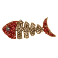 a red fish brooch sitting on top of a white surface