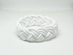 a close up of a white rope bracelet