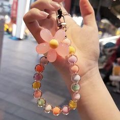 a woman holding onto a flower shaped bracelet