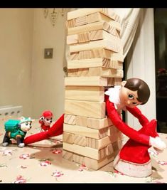 two elfs playing with wooden blocks on the floor