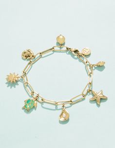 Make a splash with our Seashore Charm bracelet. Inspired by our favorite marine life, this piece shows our love for the sea. Designed to shine through everyday wear, exercise, showers and a summer at the beach in tarnish free 14kt gold vacuum plating. Cute Bracelets Flat Charms, Cheap Charm Bracelet For Beach In Summer, Cheap Summer Charm Bracelet For Beach, Cheap Summer Charm Bracelet Gift, Cute Affordable Vacation Jewelry, Cheap Charm Bracelet For Beach, Cheap Summer Gift Charm Bracelet, Affordable Casual Beach Charm Bracelet, Cute Bracelets With Charms