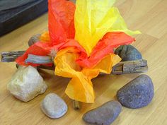 some rocks and paper on a wooden table next to a fire hydrant with an umbrella