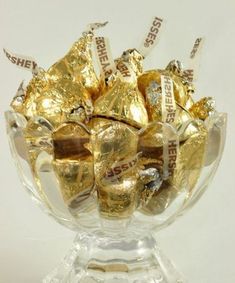 a glass bowl filled with lots of gold foil