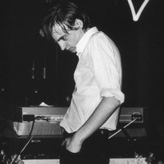 a man standing on top of a keyboard in front of a microphone