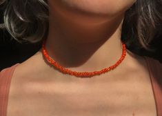 * selling this super cute (handmade by me) orange & coral/red beaded choker necklace! made with really pretty beads & gold copper wire, all held together with a lobster claw clasp. * message me with any questions or concerns & find me on instagram @crafted4coolpeople !!  * feel free to check out the multiple other color combinations of these beaded choker necklaces that i have listed on my page too! Handmade Orange Beaded Choker Necklace, Orange Beaded Choker With Tiny Beads, Orange Tiny Beads Choker Necklace, Orange Choker With Colorful Beads, Handmade Orange Choker For Gifts, Handmade Orange Choker As Gift, Orange Beaded Choker With Round Beads, Orange Beaded Choker Jewelry, Adjustable Orange Choker With Round Beads