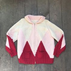 C1960s Hand Knit Ski / Skate Wool Sweater- 100% Wool- Off white coloured with pink and red ski/skate like pattern- Nice, thick and long collar-  zipper- Two small front pockets- Broad shoulders- Fits like a womans medium / large ( please refer to measurements for precise size)Measurements taken with sweater lying flat:Length: 26"Width: 22"Sleeve length: 17"In good, vintage condition showing some light marks ( see all pics on #10)  And overall wear and age White Retro Winter Cardigan, White Retro Knitted Sweater, Pink Wool Knitted Sweater, Pink Knitted Wool Sweater, Red And Pink Knitted Sweater, Retro Pink Winter Outerwear, Retro White Knit Cardigan, White Knit Retro Cardigan, Knit Zip Up Sweater