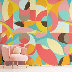 a pink chair sitting in front of a wall with colorful circles painted on the walls