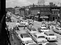 an old black and white photo of cars on the street