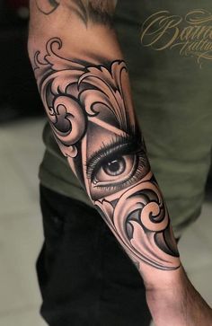 a man's arm with an eye and swirls tattoo design on the arm