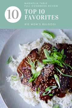 a white plate topped with meat covered in sesame seeds and green onions on top of rice