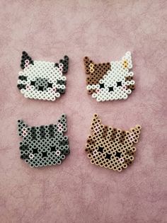 four perler beads with cats on them sitting next to each other in front of a pink background