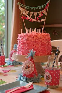 a birthday cake with candles and decorations on the table