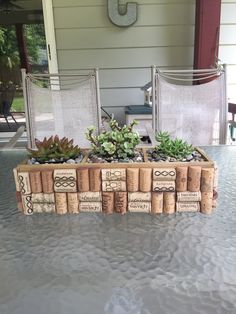 two chairs sitting on top of a table next to a planter filled with wine corks