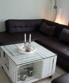 a living room with a couch, coffee table and two candles on top of it