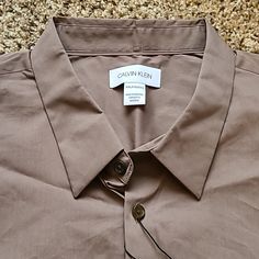 For An Additional 30 Percent Off, Just Bundle 3+ Items! Free Shipping With Orders Over $50! Calvin Klein Makes A Beautiful Line Of Dress Shirts. This Long-Sleeve Stretch Cotton Brown Shirt Is Another Hit! The Brown Color Is Called "Falcon." There Is A 'Ck' Logo On The Left Chest. Made Of 76 Percent Cotton, 21 Percent Polyamide And 3 Percent Elastane. Comes With A Extra Buttons. Made In Indonesia. Shipped From Minnesota! Calvin Klein Spring Button-up Shirt, Calvin Klein Spring Shirt With Button Closure, Calvin Klein Casual Relaxed Fit Shirt, Casual Calvin Klein Collared Shirt, Calvin Klein Casual Shirt With Spread Collar, Casual Calvin Klein Shirt With Spread Collar, Classic Calvin Klein Shirt For Spring, Classic Calvin Klein Spring Shirt, Casual Calvin Klein Button-up Shirt