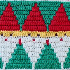 a crocheted tablecloth with red and yellow decorations on it's edges