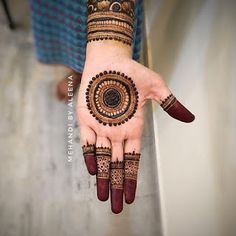 a woman's hand with henna tattoos on it