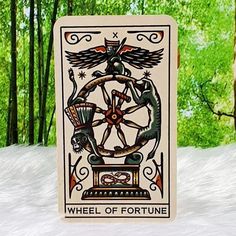 the wheel of fortune playing card is in front of some trees and snow covered ground