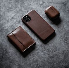 two brown leather cases sitting next to each other on top of a gray surface,